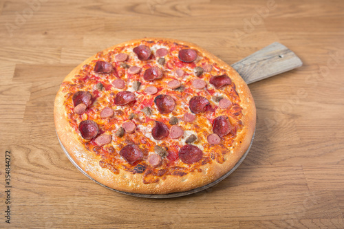 Tasty meat-lovers Pizza on wooden table 