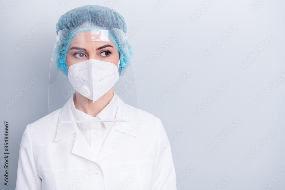 Closeup photo of attractive virologist doctor lady surgery operation save life look side dreamy wear medical gown coat mask facial plastic protect surgical cap isolated grey background Closeup photo of attractive virologist doctor lady surgery operation save life look side dreamy wear medical gown coat mask facial plastic protect surgical cap isolated grey background