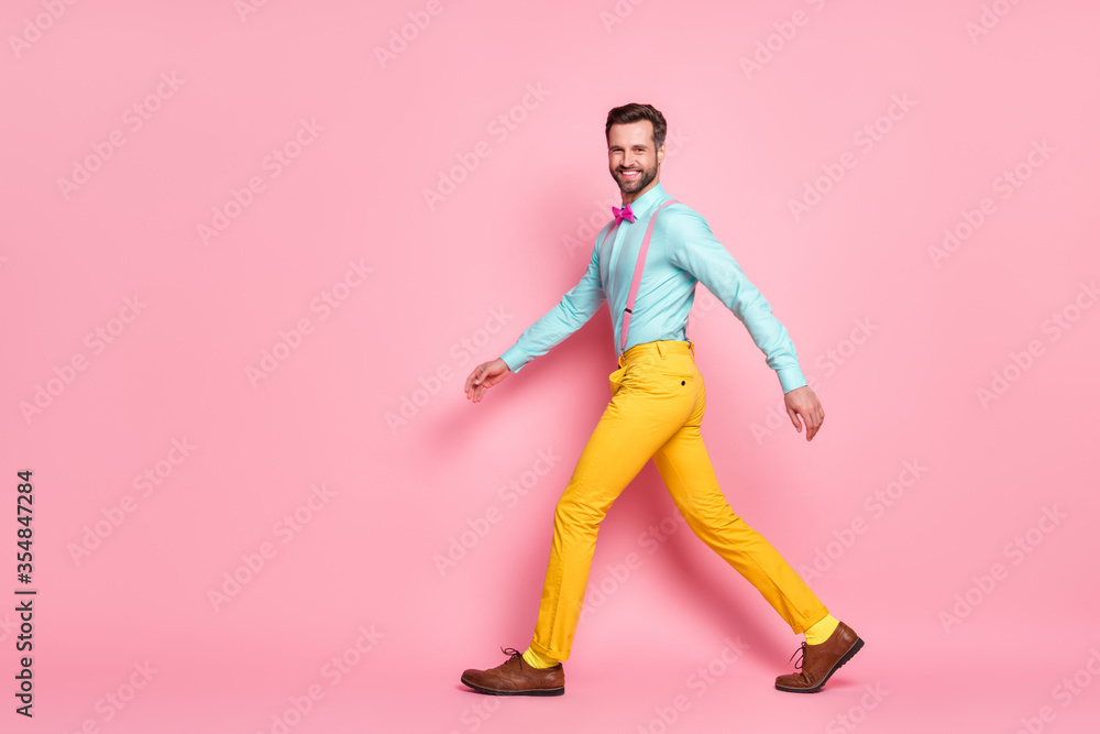 Full length body size profile side view of his he nice attractive fashionable content imposing cheerful bearded guy artist walking wearing festal clothes isolated over pink pastel color background