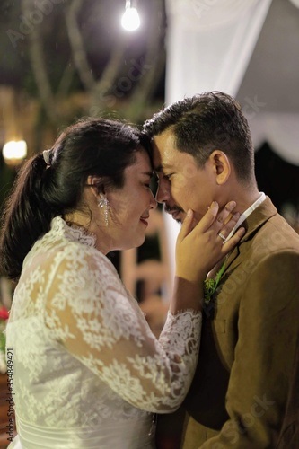 Stylish bride and groom dancing and having fun in garden. happy luxury wedding couple holding hands in light. romantic sensual moment. emotional men and woman