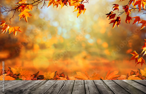 Wooden table with orange fall  leaves  autumn natural background