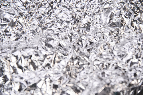 Foil aluminum crushed texture. Metal material background. Silver grunge decoration. Material pattern. Crinkle chrome paper. Fabric shine sheet. Grey color. Copyspace for text