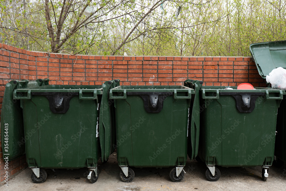 Three green trash bins in a dedicated area. Three green trash bins in a dedicated area.
