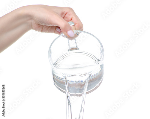 Water is pouring from a glass cup in hand on white background isolation