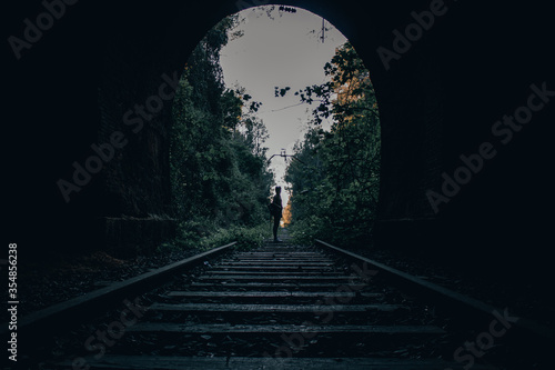 chica mirando hacia atras en un tunel de las vias del tren