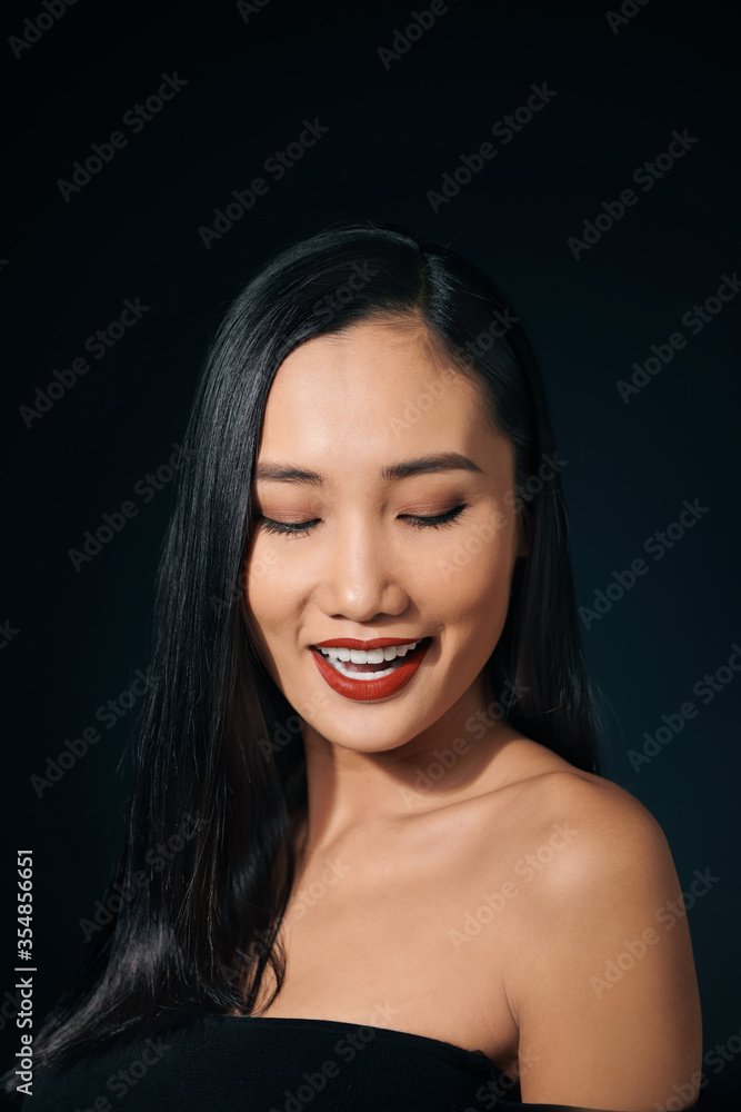 Fototapeta premium Face of the beautiful woman with long hair posing at studio over dark background