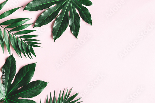 Summer composition. Tropical leaves on pink background. Summer concept. Flat lay  top view  copy space