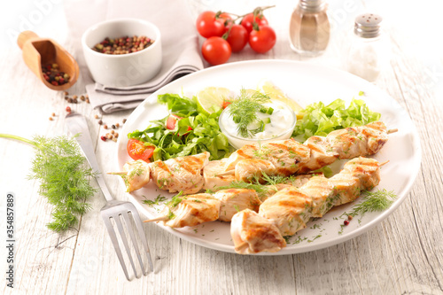 grilled chicken skewer with lettuce and sauce dip