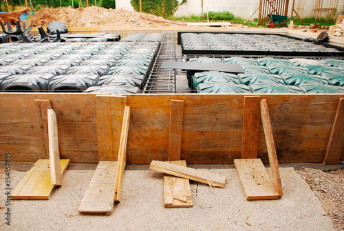 Fotografie A house foundation site with steel reinforcement cages and radon iglus surrounded by wooden shuttering