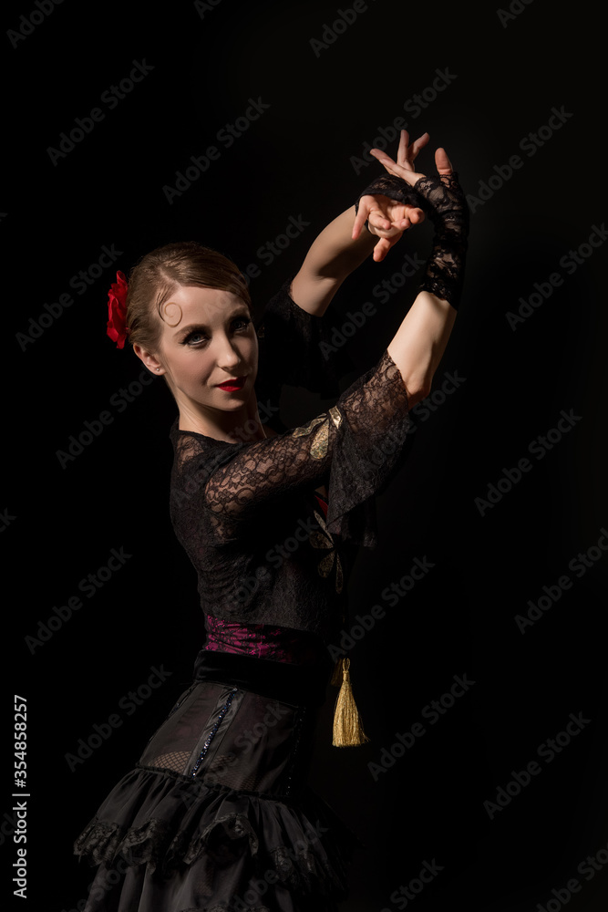 attractive dancer looking at camera and dancing flamenco isolated on black attractive dancer looking at camera and dancing flamenco isolated on black
