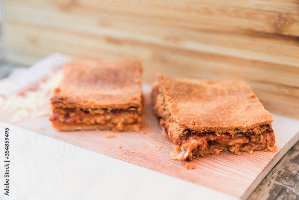 Slices of ham and cheese pastry on a wooden surface Slices of ham and cheese pastry on a wooden surface