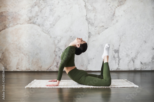 Fotografie Young woman doing pilates and yoga exercise