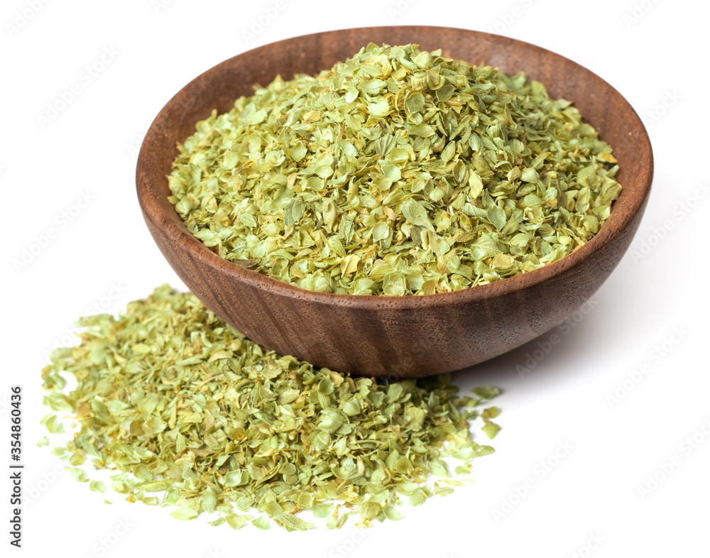 dried oregano flakes in the wooden bowl, isolated on white background dried oregano flakes in the wooden bowl, isolated on white background