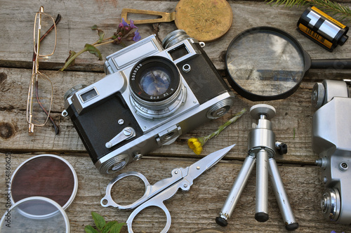 Old vintage camera with objects on wooden texture