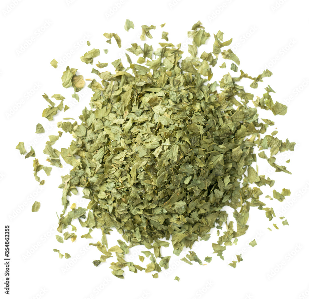heap of dried parsley flakes isolated on white background, top view heap of dried parsley flakes isolated on white background, top view
