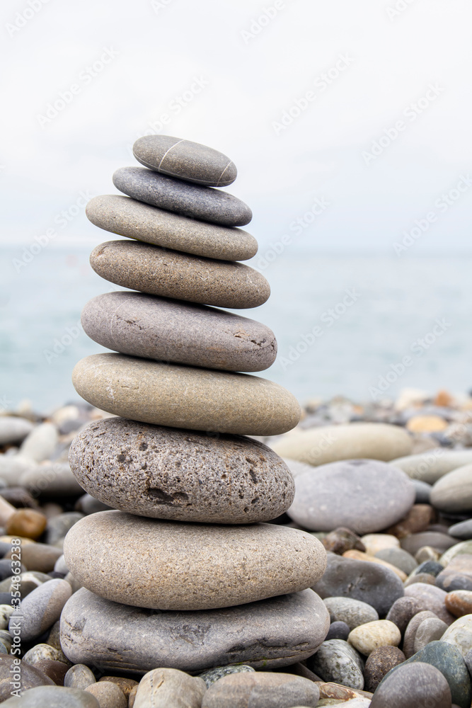 Pyramid of sea stones on the seashore at the pebble beach. Concept of harmony and balance. Pyramid of sea stones on the seashore at the pebble beach. Concept of harmony and balance.