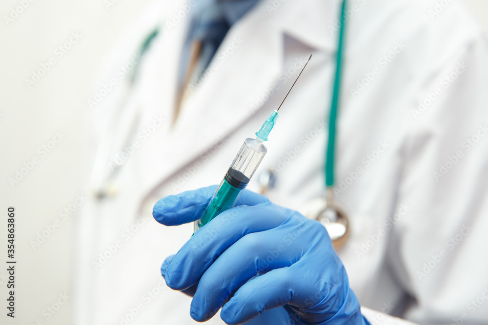 Doctor in gloves holding a medical injection syringe Doctor in gloves holding a medical injection syringe