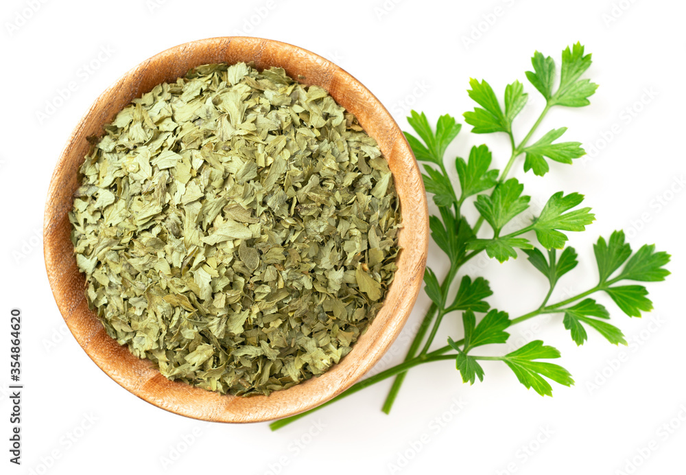 dried parsley flakes in the wooden bowl, isolated on white background, top view dried parsley flakes in the wooden bowl, isolated on white background, top view