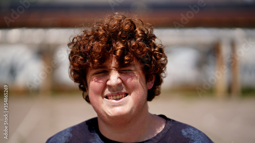 Foto A curly-haired guy lit by the sun, a teenager smiles and enjoys life