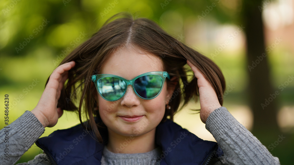 Nice girl with brown hair touching it in the park Nice girl with brown hair touching it in the park