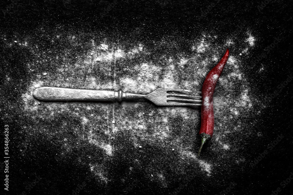 A metal fork with pepper in the sand A metal fork with pepper in the sand