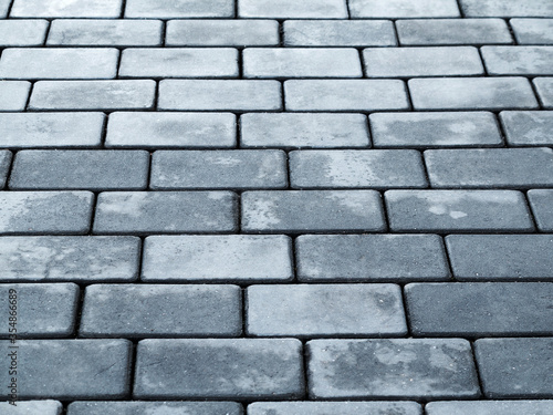 Urban road is paved with blocks of stone, cobblestone walkway, selective focus
