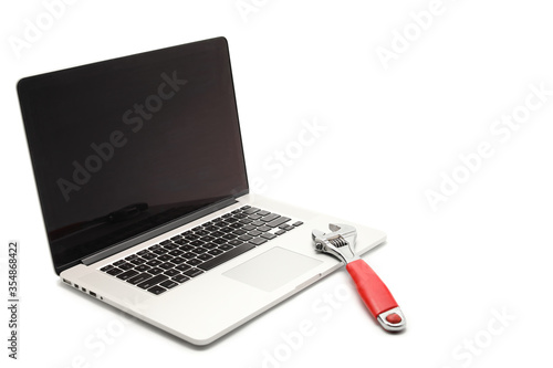 red wrench on the laptop isolated on white background