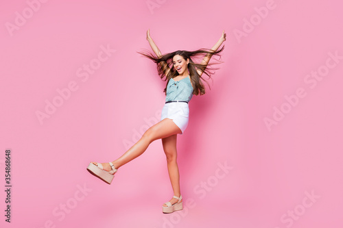 Full length body size view of her she nice-looking attractive lovely pretty charming fascinating glad cheerful girl having fun dancing wind blowing hair isolated over pink pastel color background