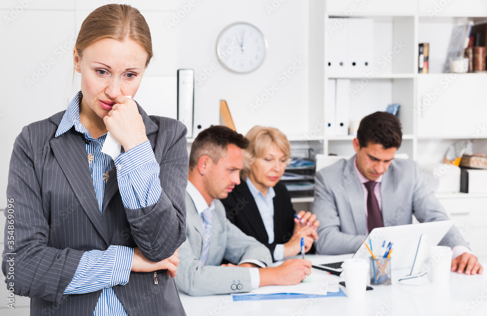 Fototapeta premium Business team solving problems with upset woman foreground