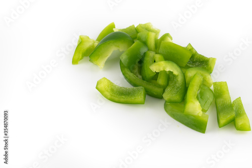 Chopped green bell pepper isolated on a white background.