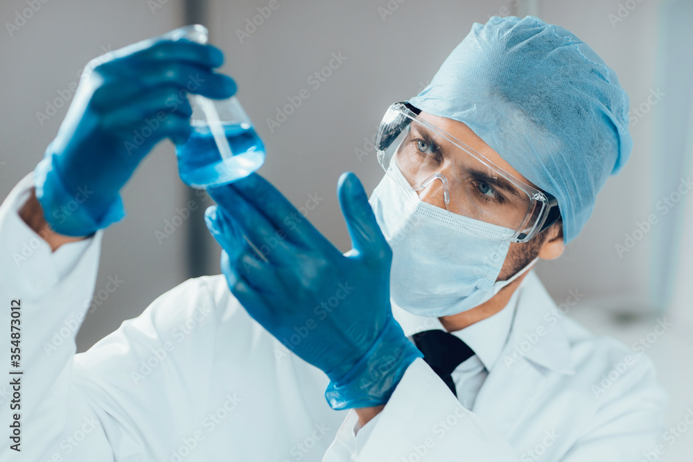 close up. researcher looking at a liquid in a medical flask. close up. researcher looking at a liquid in a medical flask.
