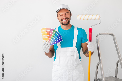 Cheerful painter with palette and paint roller