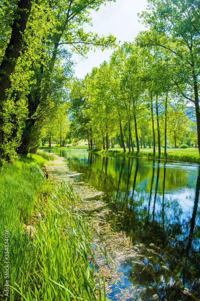Beautiful river Gacka flowing between the meadow fields in Lika region of Croatia

