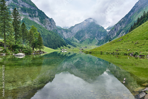 Landscape panorama from Seealpsee, Alpstein range of the canton of Appenzell, Switzerland. Green nature, mountains and their reflections on the lake.