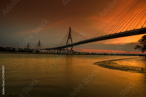 Fototapeta Naklejka Na Ścianę i Meble -  The blurred background of the twilight evening by the river, the natural color changes, the bridge over the river (Bhumibol Bridge) is one of the major transportation bridges in Bangkok, Thailand
