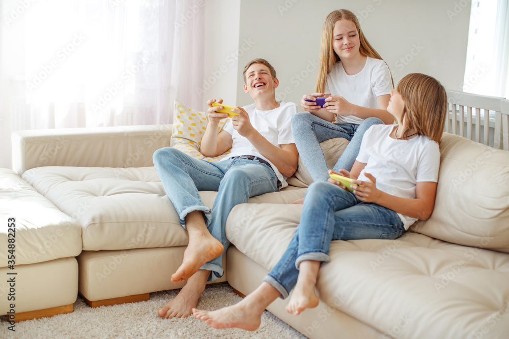 Children teenagers play a game on the phone at home. Children teenagers play a game on the phone at home.