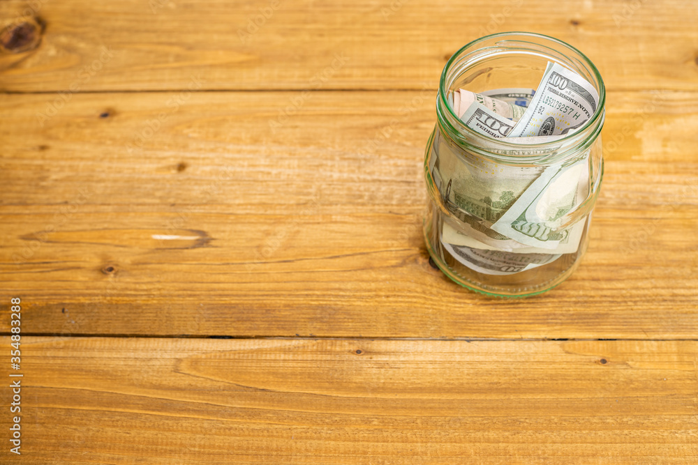 Glass jar full of money. Crisis Savings Concept. Glass jar full of money. Crisis Savings Concept.