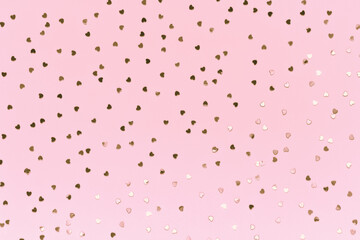 Rose gold heart confetti on pastel pink background