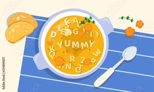 Tasty soup in a bowl with the addition of letters from pasta, greens and carrots, cooked by loving and creative parents