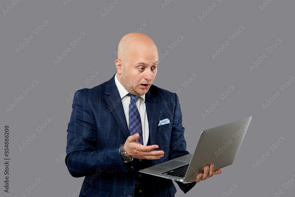 Surprised look on the face of a serious male author. Looks at the laptop. Surprised look on the face of a serious male author. Looks at the laptop.