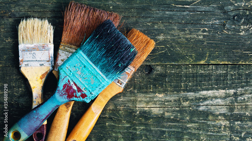 Old used brushes on a wooden background. Panorama.