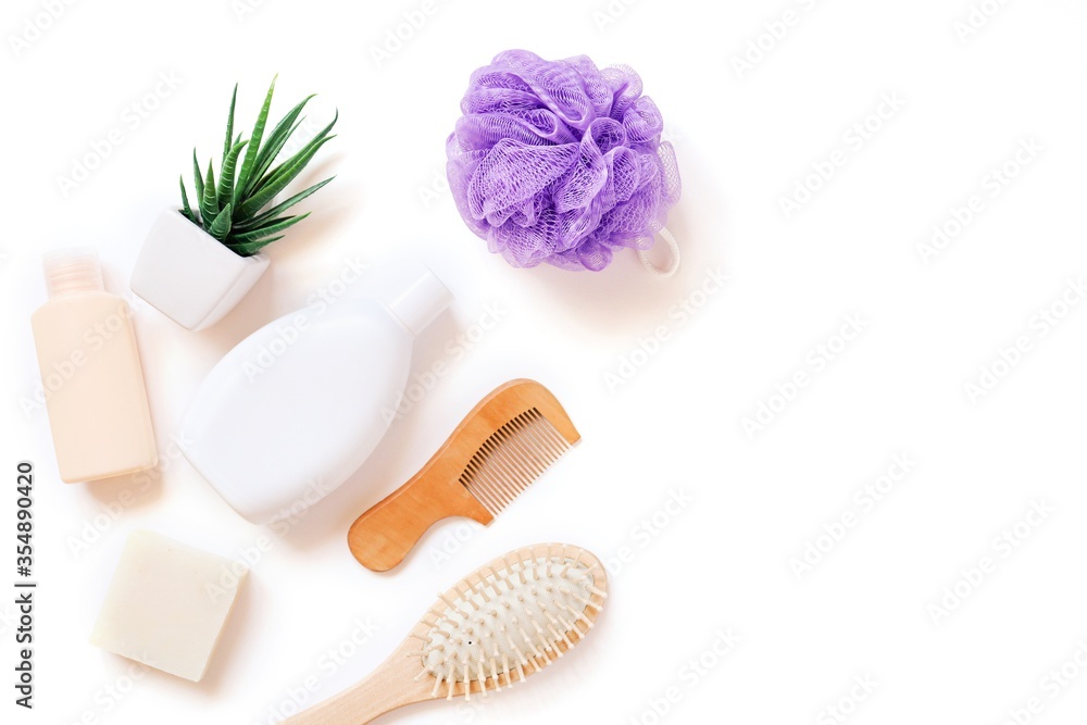 Bath accessories isolated on white. Moisturizing shampoo, herbal balm, natural soap, wooden hair brushes and purple sponge. Organic cosmetics for personal care Bath accessories isolated on white. Moisturizing shampoo, herbal balm, natural soap, wooden hair brushes and purple sponge. Organic cosmetics for personal care