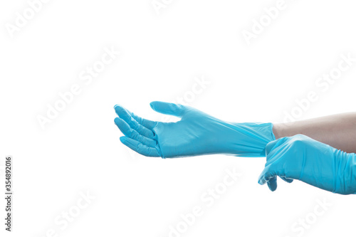 Fototapeta Naklejka Na Ścianę i Meble -  Woman hand  wearing a blue rubber medical glove on white isolated background.