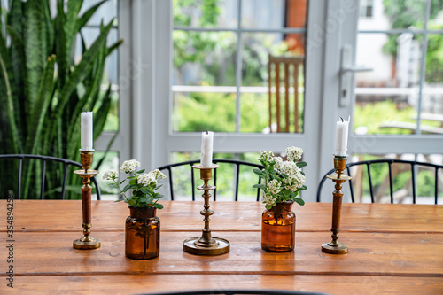 decor of dining table, candles and small white flowers. vintage. 