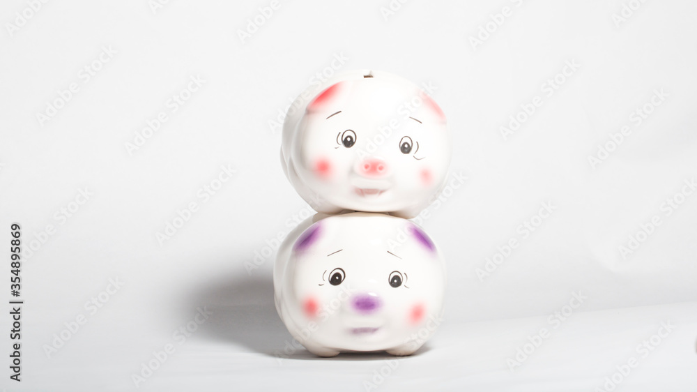 Money saving concept, with two piggy bank stacked on white background. Money saving concept, with two piggy bank stacked on white background.