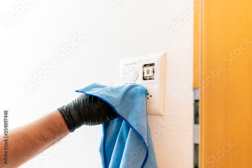close up of a professional cleaner cleaning a modern light switch and dimmer and socket