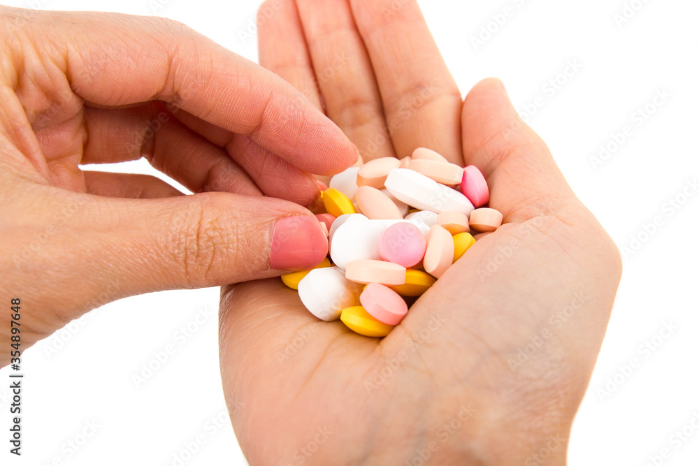 Hand with handful of scattered medicines, pills and tablets on white background. Hand with handful of scattered medicines, pills and tablets on white background.