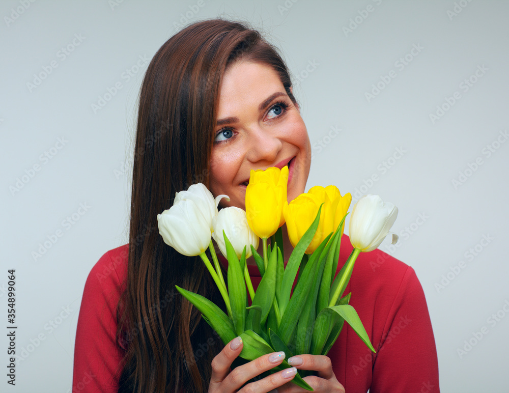 Young woman in red dress holding tulips flowers in front of herself Young woman in red dress holding tulips flowers in front of herself