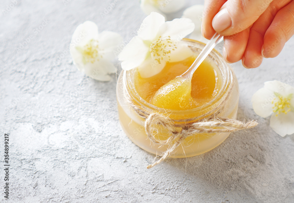 Honey - it is a natural ingredient for cosmetic skincare. Fresh golden honey is a perfect organic product for facial treatments. Female hand picks honey with a special cosmetic spoon. Honey - it is a natural ingredient for cosmetic skincare. Fresh golden honey is a perfect organic product for facial treatments. Female hand picks honey with a special cosmetic spoon.