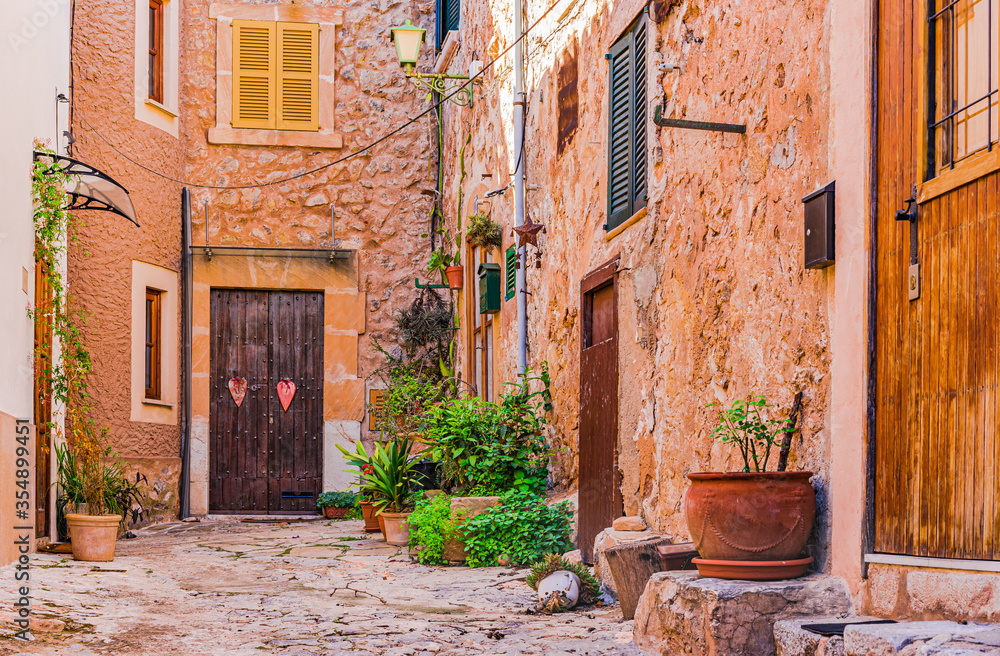 Beautiful view of a narrow alley with historic traditional mediterranean houses in an old town in Europe, Spain, Mallorca